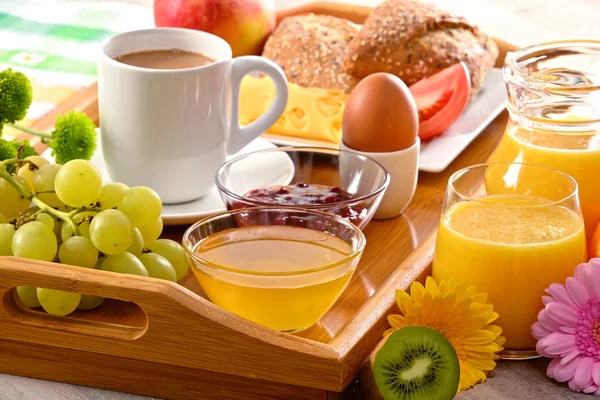 Petit déjeuner sur plateau servi avec café, jus de fruits, œufs et petits pains — Photo