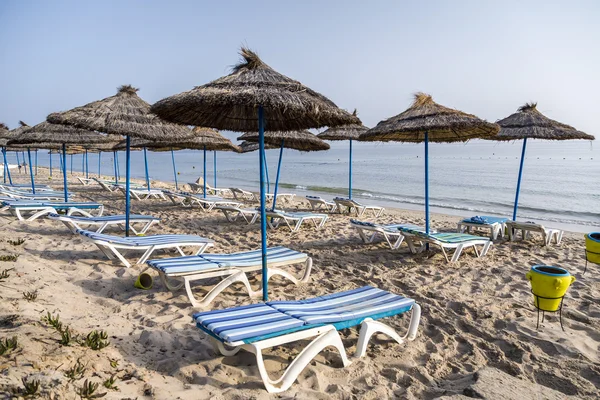 Sun umbrella on an empty beach and sea water horizon. Clear blue sky. — Stock Photo, Image