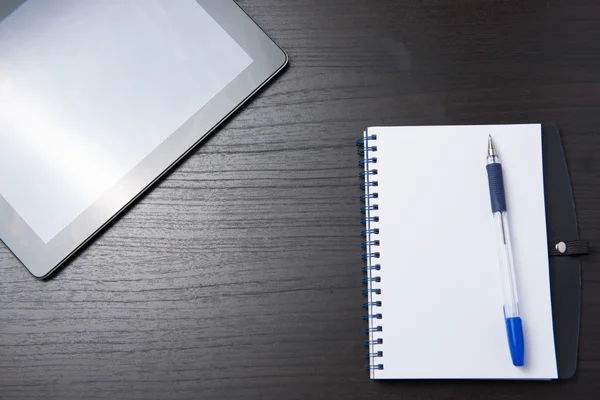 Tablet z notatnik i długopis na stół ciemny — Zdjęcie stockowe
