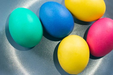 Renkli Paskalya yumurtaları tabakta yatıyor. Paskalya tatili 2021 konsepti. Metin için uygun bir yer, kartpostal için uygun. Festival geleneği.