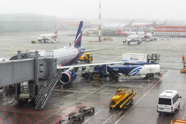 Rusya, Moskova, Sheremetyevo havaalanı, 01.04.2021. Uçak iniş terminalinin yanında duruyor, çalışanlar uçuştan önce kontrol için hazırlanıyorlar. Uçuş ertelendi. Pencerenin yanında bekletiliyor.