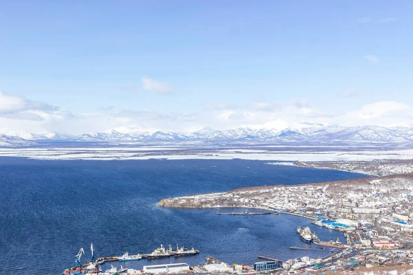A settlement in the north, houses covered with snow and a seaport. Winter landscape with mountains. the concept of life beyond the arctic circle.