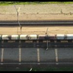 Aerial video using a drone, a cargo train on the railway, a top view over the wagons.