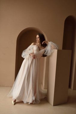 Büyümekte olan güzel bir gelinin portresi. Pencerenin yanındaki odada poz veren kız.