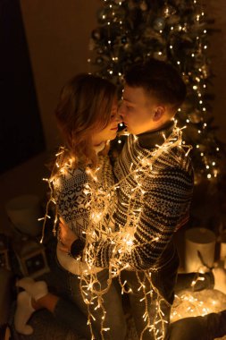 Şık kazaklı mutlu aile Noel ağacıyla şenlik odasında eğleniyor. Duygusal anlar. Mutlu Noeller ve mutlu yıllar konsepti. Mutlu tatiller