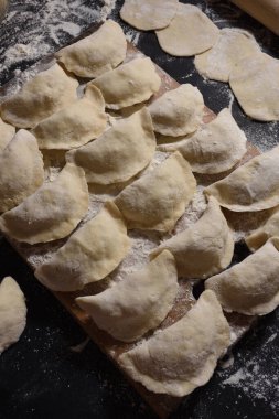 Siyah arka planda el yapımı patatesli börekler. Yukarıdan ateş edilmiş. Ukrayna halk mutfağı.