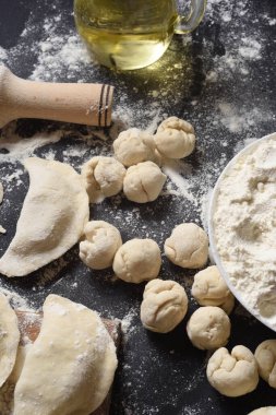 Siyah arka planda daire şeklinde hamur parçaları. Mantı mankeni. Geleneksel Ukrayna mutfağı.