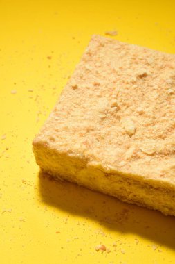 Napoleon cake on a yellow background. Shot from the side. Place for the logo