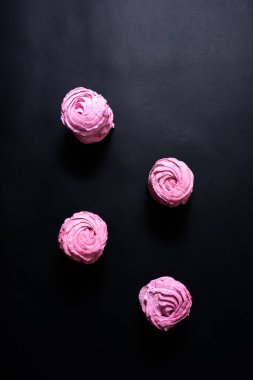 Siyah arka planda ev yapımı pembe marşmelov. Üst görünüm