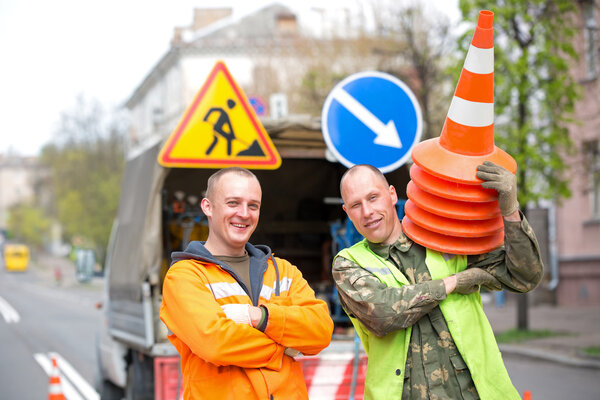 Happy road workers at city street