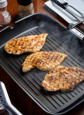 Baharatlı ve dumanlı tavada ızgara tavuk.