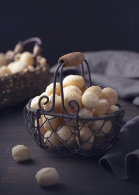 Macadamia fındıkları koyu bir ahşap arka planda izole edilmiş.