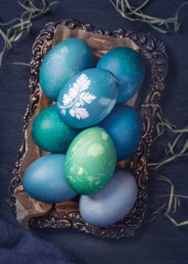 Ahşap arka planda doğal boyanmış paskalya yumurtaları. Kırmızı lahanayla boyanmış. Yeşilimsi mavi lahanalar için gazoz kullanılabilir..
