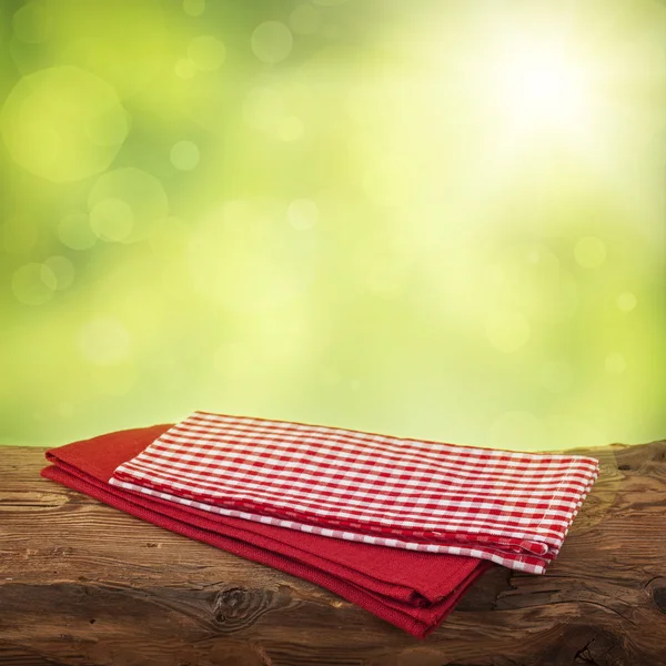 Empty wooden table with red napkins — Stock Photo, Image