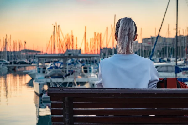 Симпатичная девушка сидит на скамейке — стоковое фото
