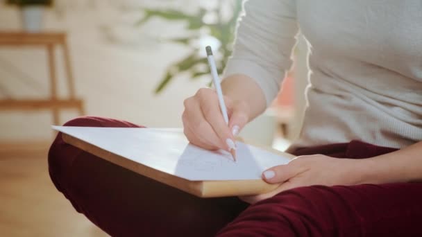 Mujer artista Bocetos sobre el Libro Blanco Sentado en el suelo — Vídeo de stock