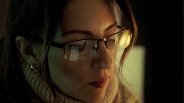 Mujer bonita en gafas de vista tarde en la noche desplazándose con el teléfono inteligente — Vídeos de Stock