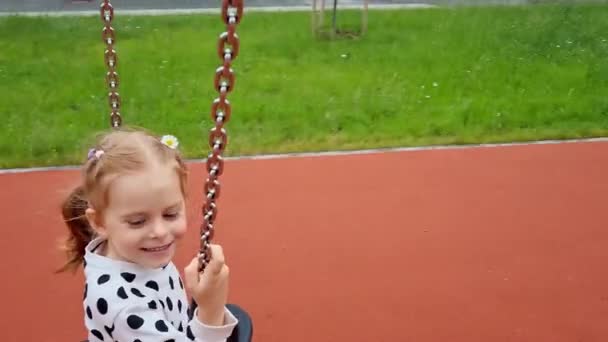 Chica feliz girando en carrusel en un colorido parque infantil en el día de verano. — Vídeos de Stock