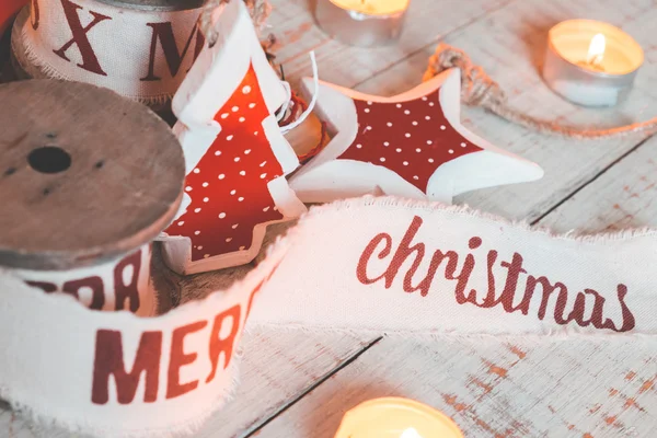 Красиві вінтажні різдвяні стрічки та іграшки на дерев'яному столі. Милі і приємні прикраси в сільському стилі — стокове фото