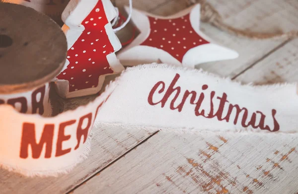 Bellissimi nastri natalizi vintage e giocattoli sul tavolo di legno. Decorazioni carine e piacevoli in stile rustico — Foto Stock