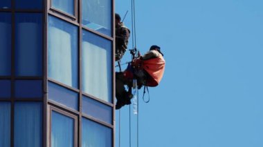 Endüstriyel tırmanışçılar güneşli bir günde binada çalışıyorlar.