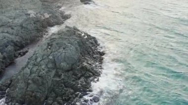 Dalgalar denizde kayaları, havadan manzarayı yıkar.