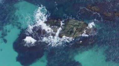 Üst manzara dalgaları denizde kayaları yıkar.