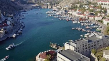 Balaklava şehrindeki körfezde tekneleri olan iskele, deniz trafiği, hava manzarası