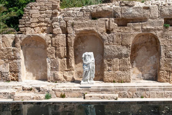 The statue of a Roman emperor in the ancient podium of the Roman temple inside the Caesarea national park. Israel