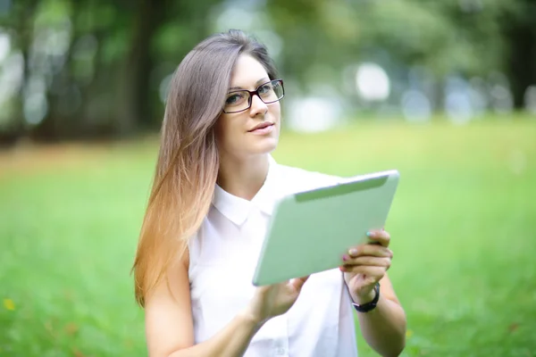 Jovem, garota trabalhando com tablet e telefone em campo verde, parque com sol — Fotografia de Stock