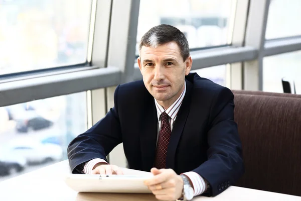 Zufriedener Geschäftsmann am Arbeitsplatz mit Blick auf die Kamera im Büro — Stockfoto