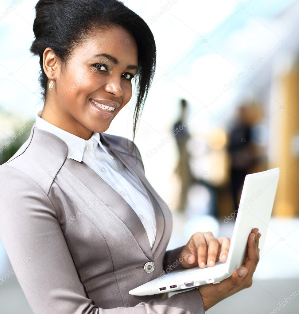 Smiling african businesswoman with laptop computer
