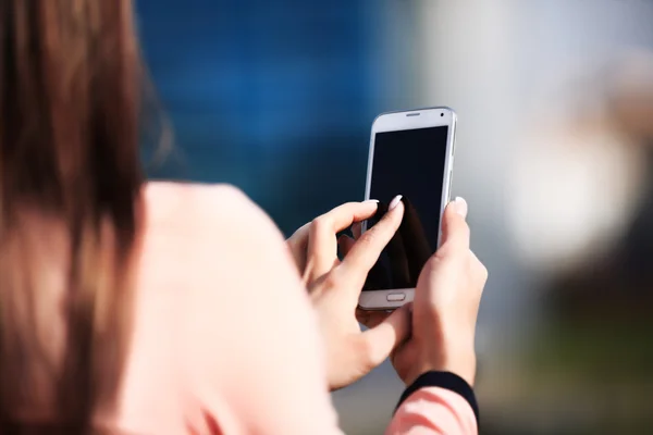 Jovem mulher de negócios bonita escreve um SMS para o seu telefone móvel — Fotografia de Stock