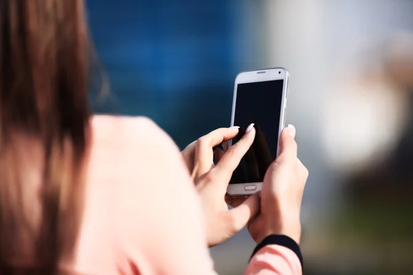 Young beautiful business woman writes an SMS to your mobile phone — Stock Photo, Image