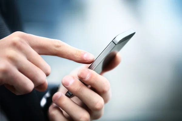 Fechar de um homem usando telefone inteligente móvel — Fotografia de Stock