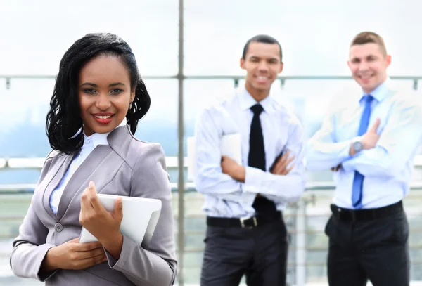 Zakelijke vrouw met haar personeel, mensen groep in de achtergrond op moderne lichte kantoor binnen — Stockfoto