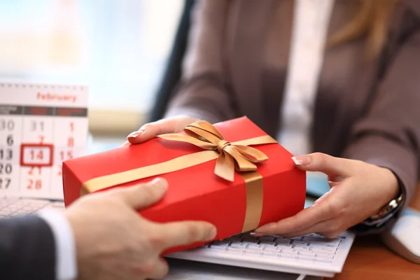 Homem de negócios oferecendo um presente para uma mulher — Fotografia de Stock