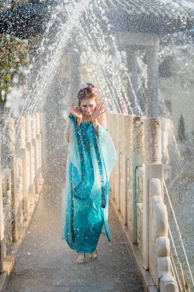 Красивая молодая гейша в каплях воды в голубом платье — стоковое фото
