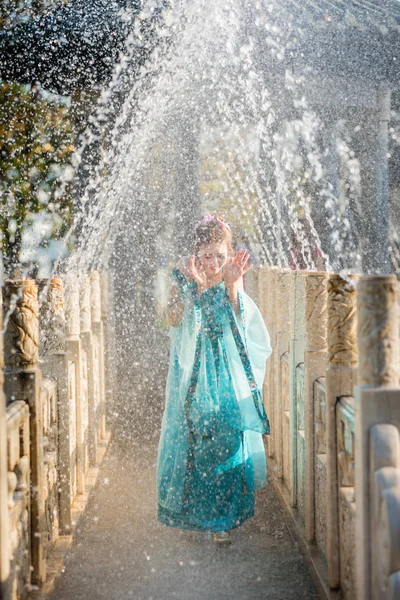 Красивая молодая гейша в каплях воды в голубом платье — стоковое фото