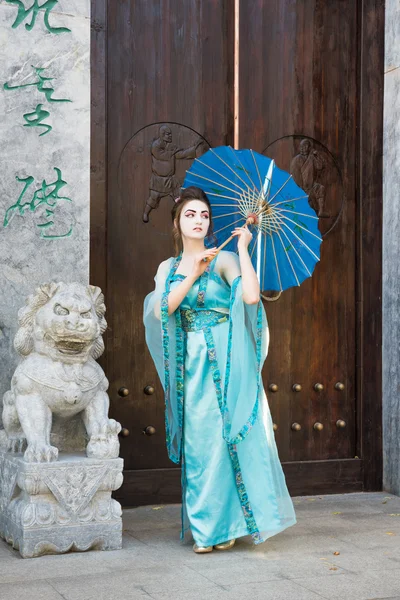 Prachtige geisha met een blauwe paraplu — Stockfoto