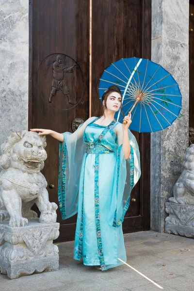 Prachtige geisha met een blauwe paraplu — Stockfoto