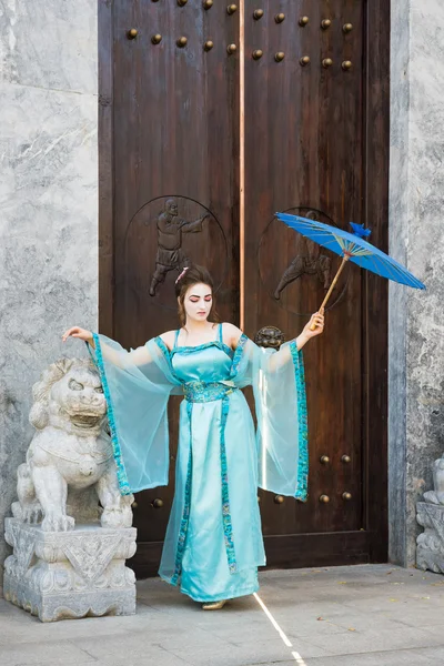 Prachtige geisha met een blauwe paraplu — Stockfoto