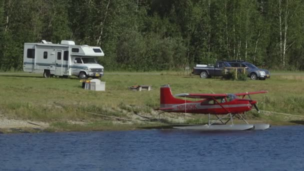 Fairbanks, Alaska, USA - 2015年7月。フェアバンクス国際空港の湖に浮かぶ飛行機駐車場。キャンパー・バンが海岸に停まった — ストック動画