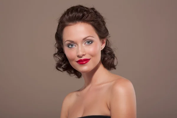 Face of a beautiful young brunette woman with bright lipstick and curly hair — Stock Photo, Image