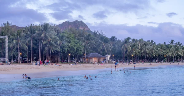 Nadar por la noche en la famosa playa de Waikiki — Foto de Stock