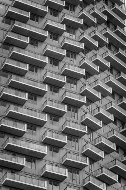 Modern apartman kulesinin siyah beyaz görüntüsü.