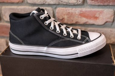 Calgary, Alberta - 26 Ekim 2025: Converse All Star ayakkabı ve tuğla kaplama arka plan.