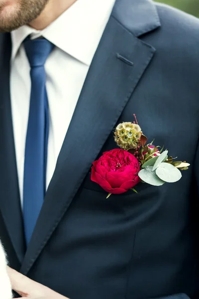 Grooms with blue tie and red rose boutonniere on wedding day — Stock Photo, Image