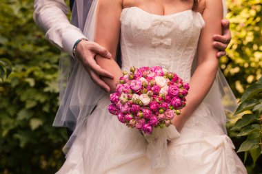 Gelin ve damat gelin buketi tutarak yakından