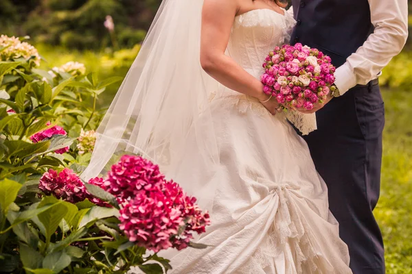 Жених и невеста держат свадебный букет крупным планом — стоковое фото
